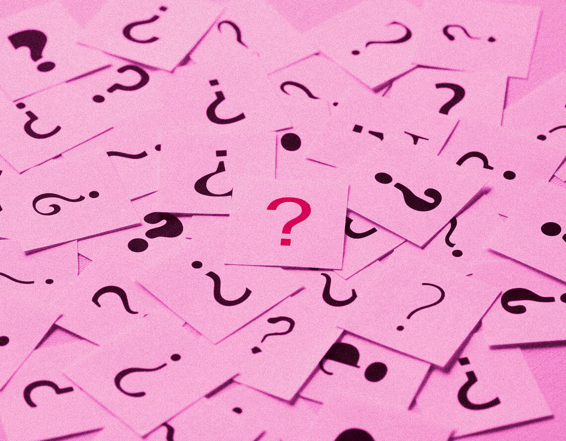 numerous question mark papers scattered around a table